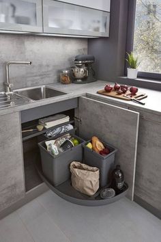 a kitchen with grey cabinets and gray counter tops, an open sink area is shown