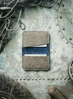 a wallet sitting on top of a pile of rope next to an object with blue and white stripes