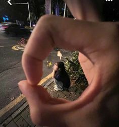 a person sitting on the ground with their hand in front of them