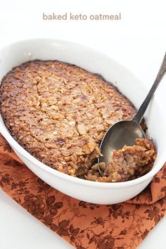 baked keto oatmeal in a white bowl with a spoon on an orange napkin