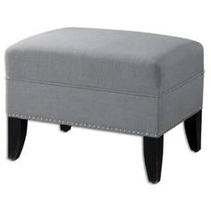 a grey foot stool with studded legs