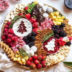 a platter filled with cheese, crackers and berries