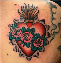 a heart tattoo with roses and a crown on the back of its head is shown