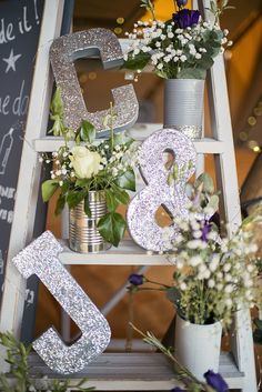 an old ladder is decorated with flowers and numbers for a birthday party or anniversary celebration