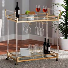 a gold bar cart with wine glasses and bottles