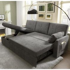 a couch with a pull out bed underneath it in a living room next to a fireplace