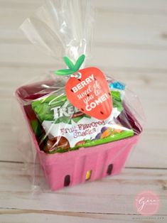 a pink basket filled with fruit and candy