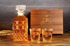 a bottle of brandy next to two glasses and a wooden box with the name branon on it