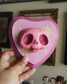 a pink heart shaped box with a skull inside