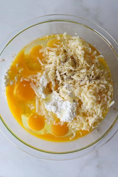 a bowl filled with eggs and cheese on top of a table