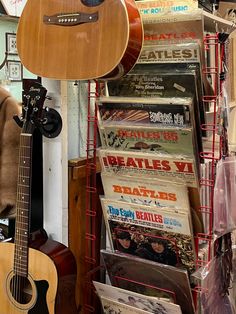 an acoustic guitar is on display in front of magazines and other memorabilia at a store