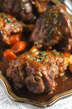 some meat and carrots on a plate with gravy