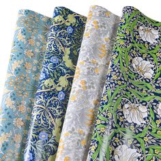 four different colored fabrics are lined up in the same pattern, each with flowers and leaves on them