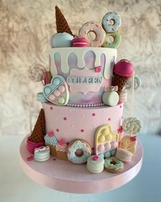 a three tiered cake decorated with ice cream and donuts