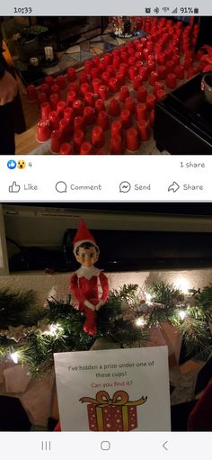 an elf is sitting on top of a christmas tree with red cups in front of him