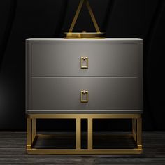 a grey and gold chest with two drawers on it's sides, in front of a black background