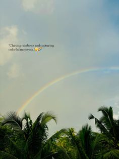 there is a rainbow in the sky above some trees and palm trees with a quote on it