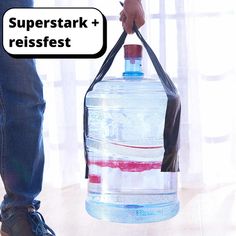 a person holding a large water bottle with the words superstark reisefest on it