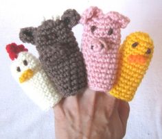 four crocheted finger puppets in the shape of chickens, pigs, and corn on the cob