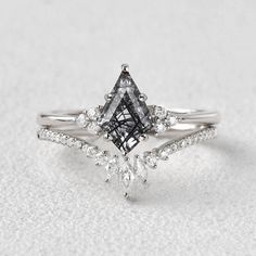 an engagement ring with two pear shaped diamonds on the side and a diamond set in the middle