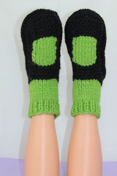 there is a pair of black and green knitted socks on top of a mannequin's legs