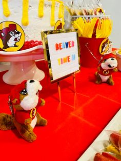 a table topped with stuffed animals next to a sign