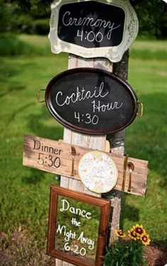 a wooden sign with chalkboard signs attached to it's sides in the grass