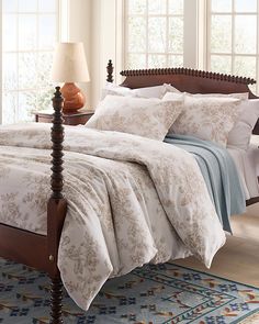 a bed with white and blue comforters in a bedroom