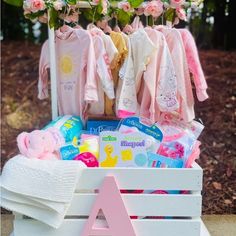 a wooden crate filled with baby clothes and toys