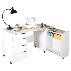 a sewing machine sitting on top of a desk next to a white cabinet with drawers