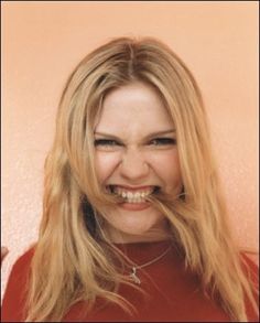 a woman with long blonde hair has a fake moustache on her face and is smiling