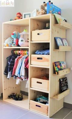 a wooden shelf filled with lots of children's clothing