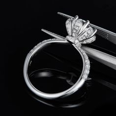 a diamond ring sitting on top of a pair of scissors