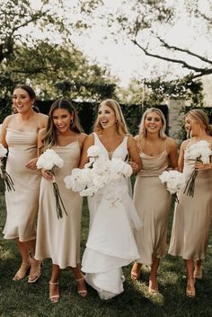 a group of women standing next to each other holding bouquets