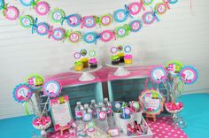 a pink and blue dessert table with cupcakes, candy bars, and decorations