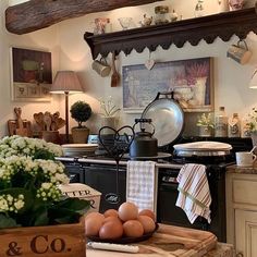 an old fashioned kitchen with eggs on the counter and flowers in vases next to it