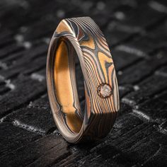 "This unique and modern feeling Mokume Gane ring is shown in the Twist pattern and the Firestorm metal combination, with a flat profile and an added flush set cognac diamond. This ring is made in a soft square shape for a unique style that still feels comfortable on the hand! Our Firestorm palette features 14k Red Gold, 14k Yellow Gold, Palladium, and Sterling Silver.  *Price does NOT include stones or setting fees* Pattern: Twist Palette: Firestorm Finish: Etched & Oxidized Profile: Flat Width Shown: 6mm Size Shown: 8.5 Stone: 3mm Cognac Diamond Price as shown for this width and ring size! If you are interested in this design please inquire for an accurate quote! We care about customer service and would like to hear from you! Please contact us to help create your treasured item, we take y Modern Brown Jewelry For Anniversary, Modern Brown Rings For Anniversary, Modern Brown Rings For Gifts, Modern Brown Rings For Gift, Luxury Brown Ring For Gift, Luxury Brown Rings For Gift, Luxury Brown Rings As Gifts, Modern Brown Anniversary Ring, Formal Brown Engraved Ring