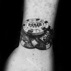 a black and white photo of a man's wrist with poker chips on it