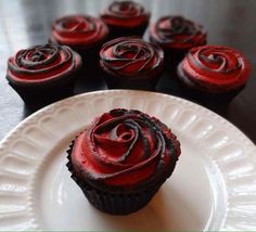 red cupcakes with chocolate frosting on a white plate