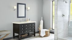 a bathroom with a sink and mirror next to a walk - in shower stall area