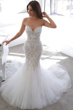 a woman in a wedding dress standing next to a piano