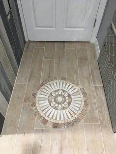 a tile floor with a white door in the background and a circular design on it