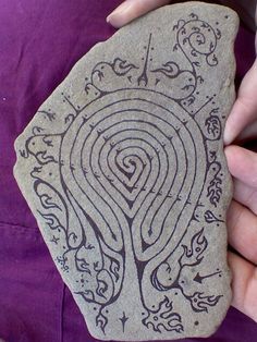 a person holding a rock with an intricate design on it