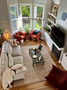 a living room filled with furniture and a fire place in front of a flat screen tv