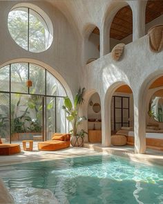 an indoor swimming pool with circular windows and round seating area next to it, surrounded by greenery