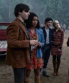 a group of people standing next to each other in front of a red pickup truck