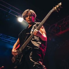 a young man playing an electric guitar on stage