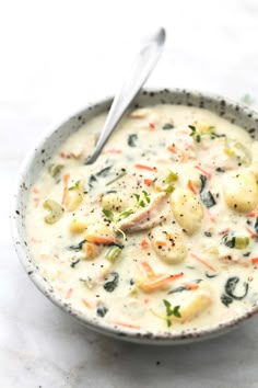 a bowl of soup with potatoes, carrots and broccoli on the side