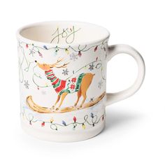 a white coffee cup decorated with reindeers and snowflakes