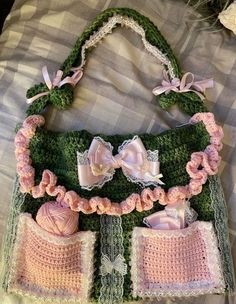 a crocheted purse with pink and green trimmings on the bottom, along with matching baby booties